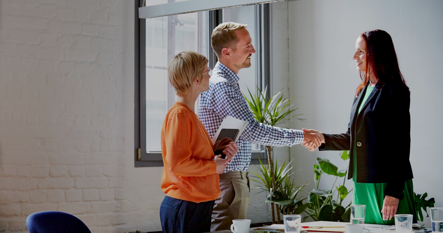 People in an office, shaking hands, making a deal