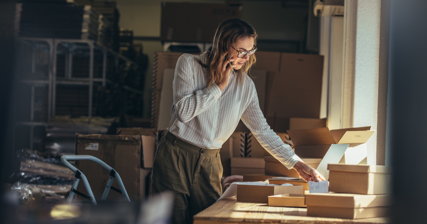 Woman on the phone standing in a warehouse